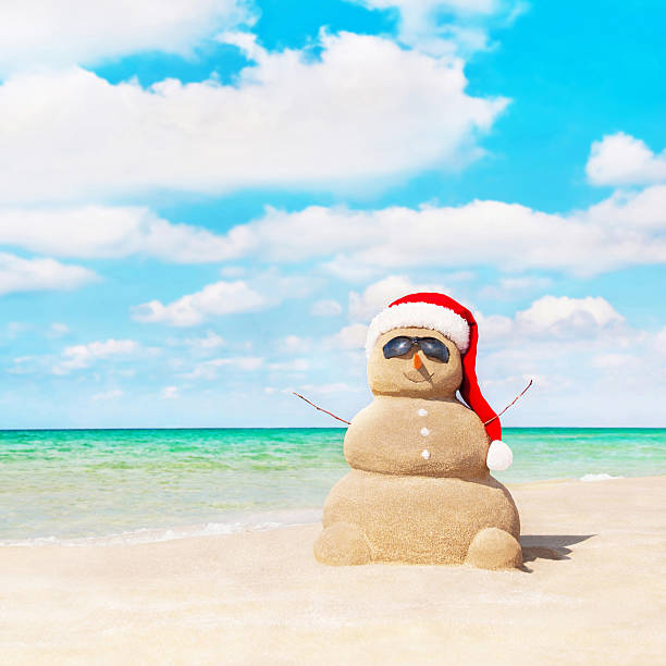 istock Sandy snowman in santa hat at beach. Christmas concept 530202197