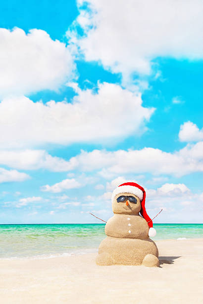 istock Sandy snowman in santa hat at beach. Christmas concept 530202201