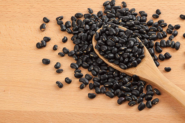 istock Black beans with wooden spoon 530202273