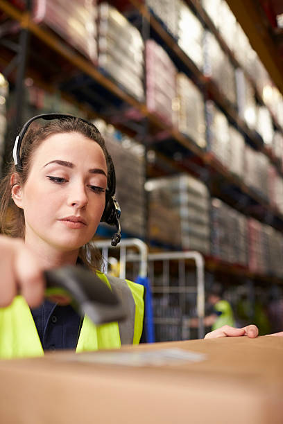 istock Woman uses barcode reader in a warehouse, vertical close-up 530202836