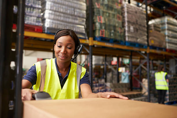 Woman using a barcode reader in a distribution warehouse Woman using a barcode reader in a distribution warehouse distribution warehouse stock pictures, royalty-free photos & images