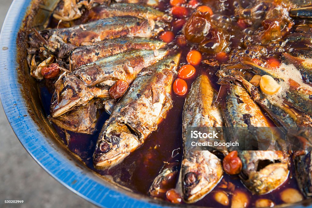 Traditional Thailand Street Food Fish This is a horizontal, color photograph of a large bowl filled with whole fish in a boiling, hot red sauce. Photographed from above with a Nikon D800 on the streets leading to the Amphawa Floating Market. Amphawa District Stock Photo