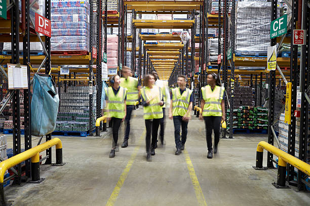 istock Staff in reflective vests walking to camera in a warehouse 530203038