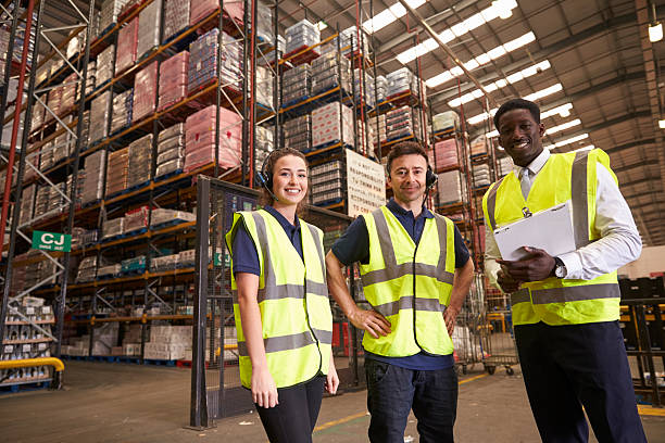 istock Distribution warehouse manager and colleagues look to camera 530203182