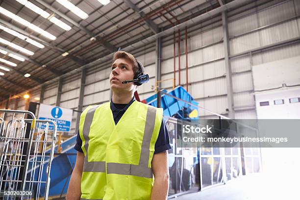 Man With Reflective Vest And Headset Standing In A Warehouse Stock Photo - Download Image Now