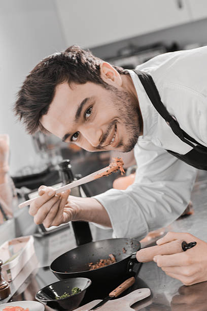 istock Man happy in kitchen tasting with a wooden spoon 530203840