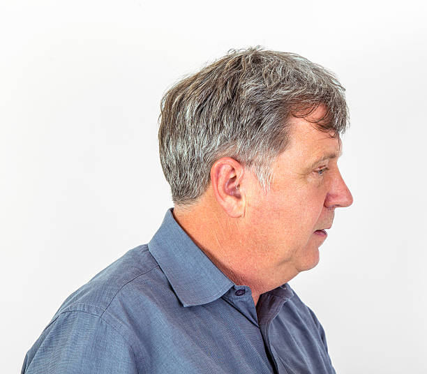 istock serious man in shirt handling his  hearing aid 530204259