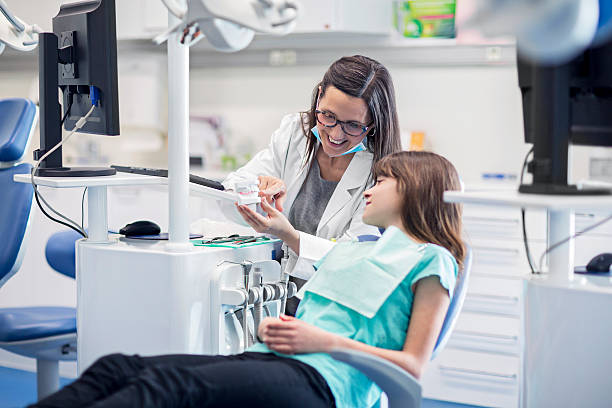 zahnarzt zähne modell mit der assistent für mädchen - dentist dentist office patient discussion stock-fotos und bilder