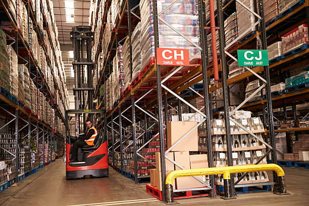 istock Man using aisle truck in a distribution warehouse, side view 530204614
