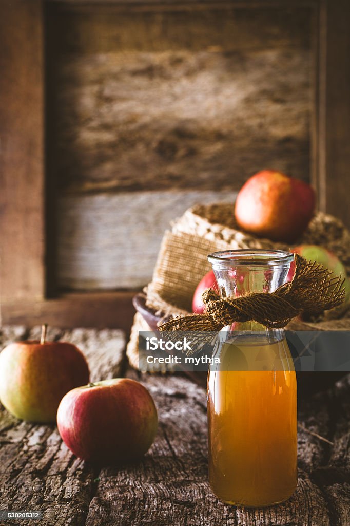 Apple vinegar Apple vinegar. Bottle of apple organic vinegar on wooden background. Healthy organic food. Hot Apple Cider Stock Photo