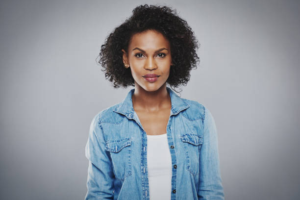 schwere schwarze frau mit blauen jeans-shirt - women african descent serious human face stock-fotos und bilder