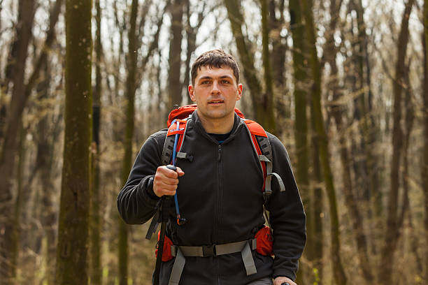 istock Male hiker looking to the side walking in forest 530208082