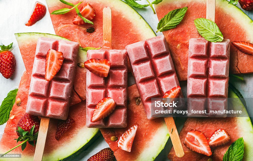 Strawberry watermelon ice cream popsicles with mint over steel tray Strawberry watermelon ice cream popsicles with mint over steel tray background. Top view, horizontal Berry Fruit Stock Photo