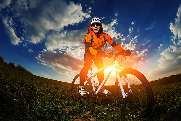 istock biker in orange jersey riding on green summer field 530208996