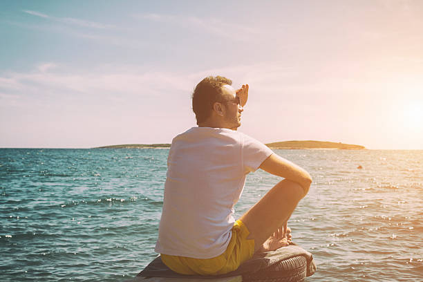 istock Hipster man taking photos with camera at the beach. 530209284