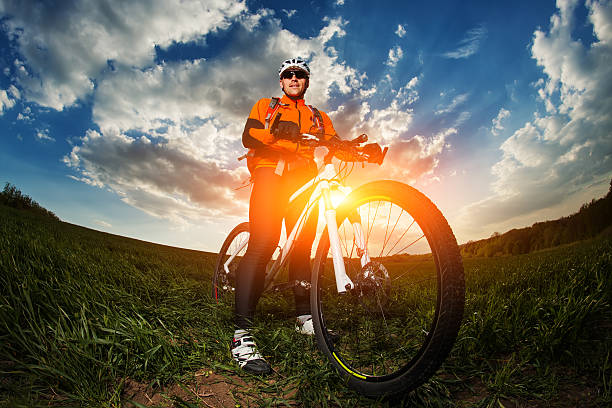 istock biker in orange jersey riding on green summer field 530209290