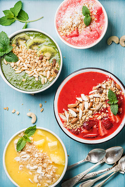 istock Healthy summer breakfast concept. Colorful fruit smoothie bowls on turquoise 530209342