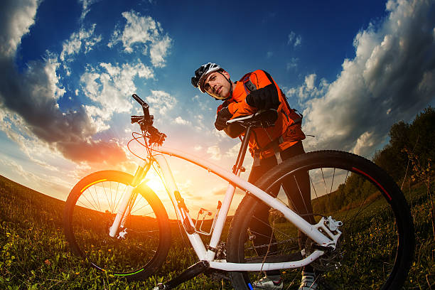 istock biker in orange jersey riding on green summer field 530209756