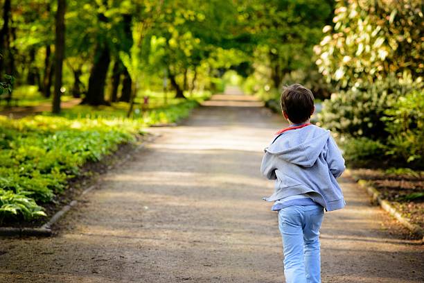 Children's Day.  Little boy running in the park. Back view
