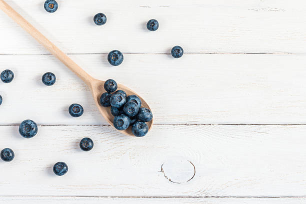 blueberry on wooden spoon, flat lay, top view