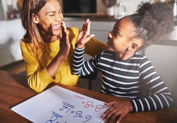 Learning to calculate, high five success Learning to calculate, high five success, black mother and child homework stock pictures, royalty-free photos & images