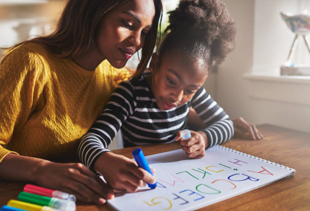 istock Little girl writing the alphabet 530211628