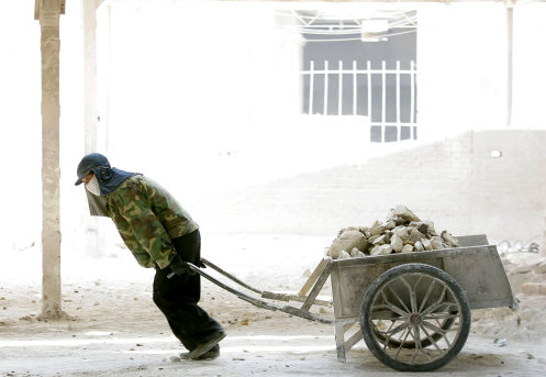 BEIJING - JUNE 4: A Chinese labourer works at a lime factory on June 4, 2005 in Beijing, China. Plans are underway to improve the capitals pollution problems ahead of the 2008 Olympic Games following the Olympic action plan which promised to spend 5.4 billion USD by 2008 to make Beijing an \