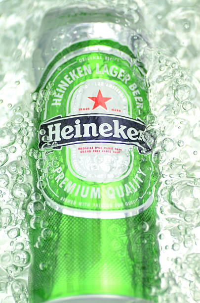 heineken lager-bier in sonnenverwöhnte wasser - sprinkling can stock-fotos und bilder