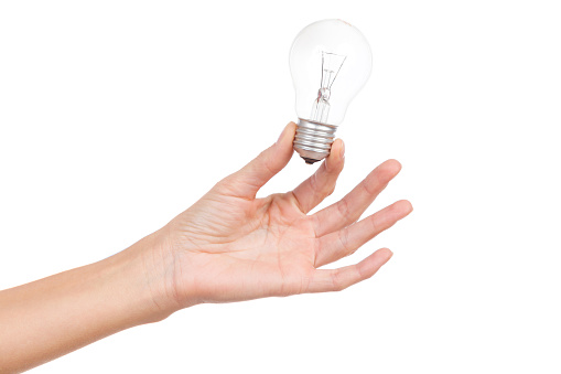 Close up of woman's hand holding light bulb. Studio shot isolated on white.