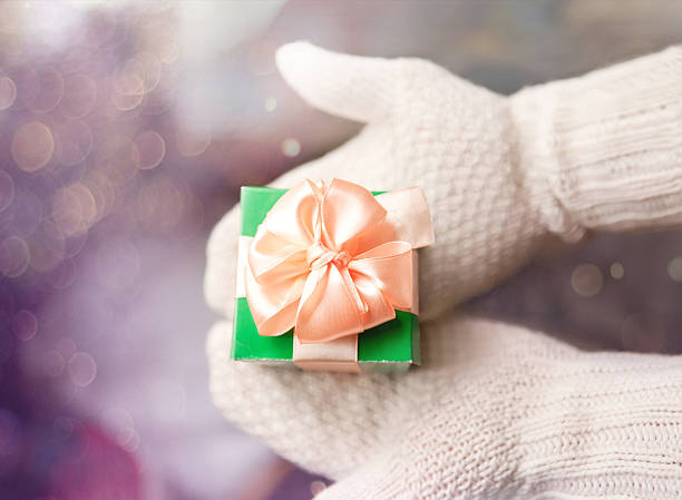 istock gift in hands with mittens on winter magic background 530227005