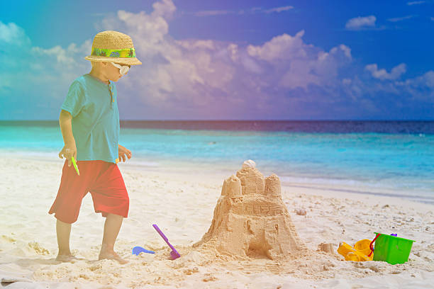 istock little boy building sand castle on beach 530227605