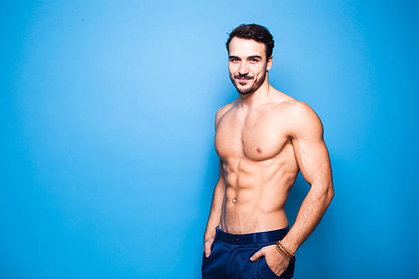 shirtless man with beard on blue background stock photo
