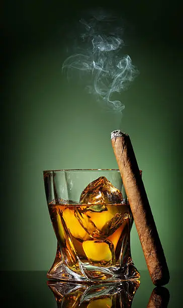 Photo of Whiskey and cigar on green