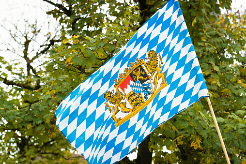 bavarian flag in a german beer garden with autumn leaves in the background
