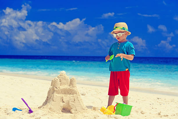 istock little boy building sand castle on beach 530237277
