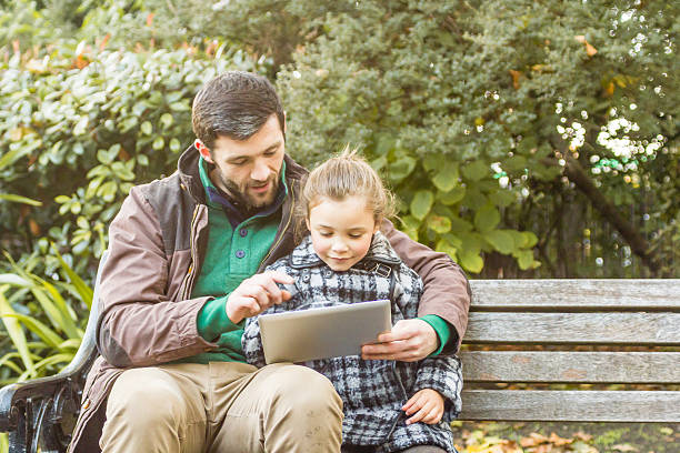 istock Father And Daughter Using Tablet computer in the park 530238411