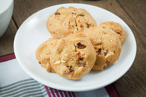 istock Chocolate chip cookies on white disk on wooden table 530238547