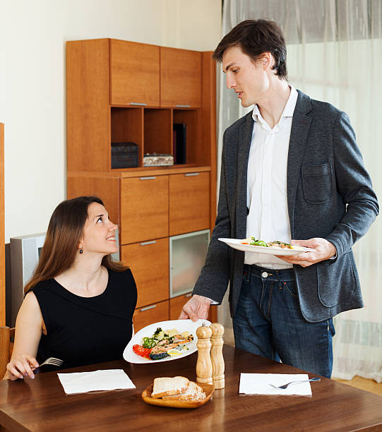 istock Smiling man serving dinner to beloved woman 530240569