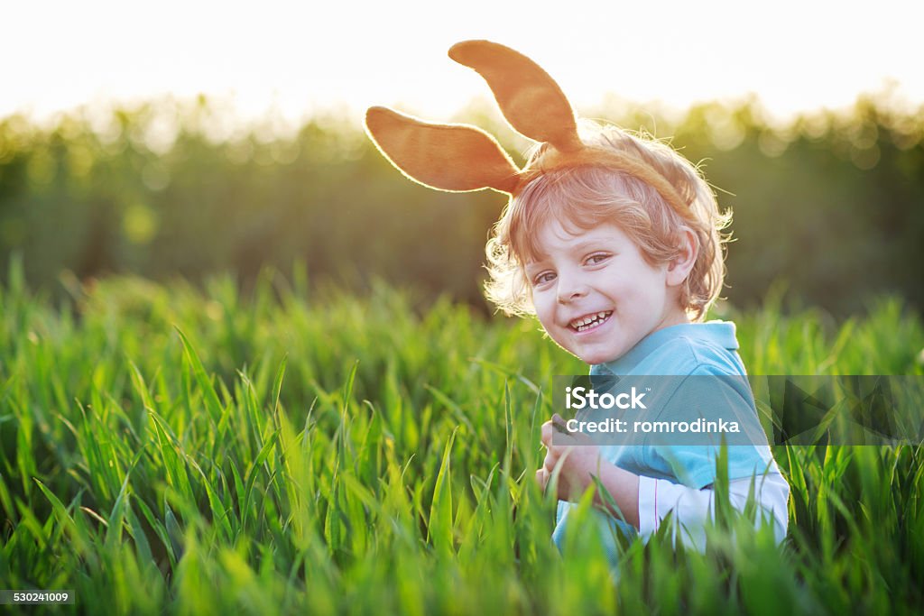Linda poco niño con orejas de conejo de pascua en verde hierba - Foto de stock de 2-3 años libre de derechos