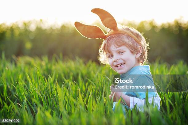 Linda Poco Niño Con Orejas De Conejo De Pascua En Verde Hierba Foto de stock y más banco de imágenes de 2-3 años