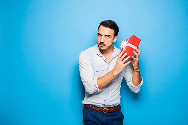 handsome adult man on blue background with christmas gift stock photo