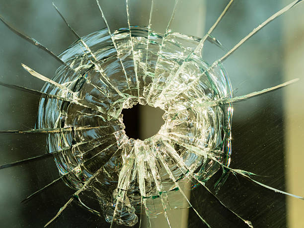 istock bullet hole on glass making cracks 530250931