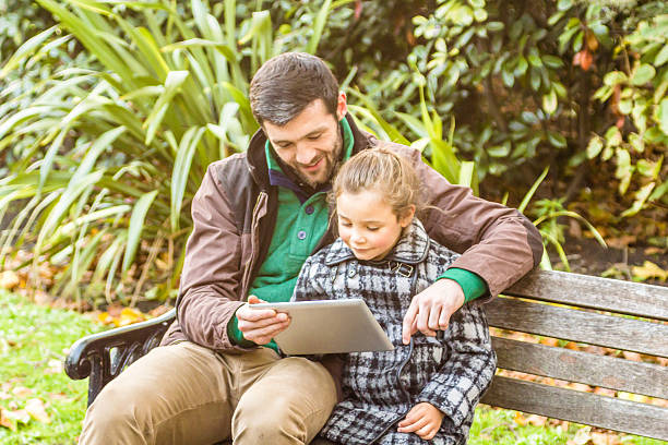 istock Father And Daughter Using Tablet computer in the park 530251211