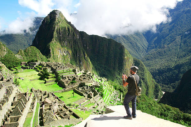 Traveler taking picture with cell phone in Machu Picchu, Peru stock photo