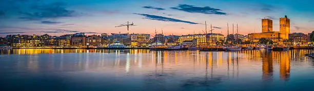 Photo of Oslo waterfront illuminated dusk City Hall harbour Aker Brygge Norway