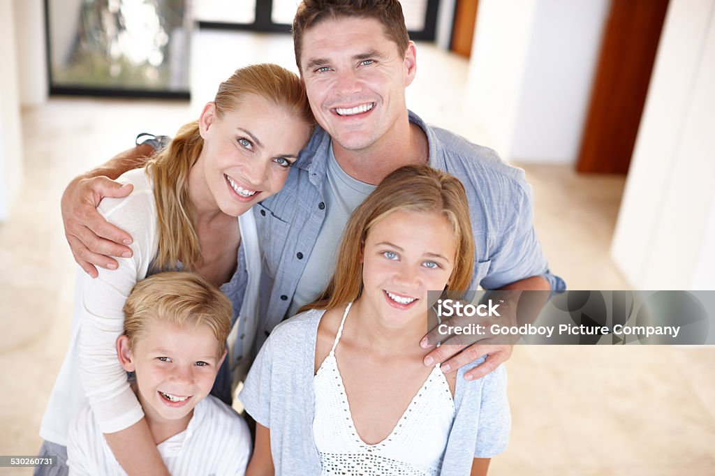 Weekends with the family Cropped portrait of a happy young family of four standing in their home Adult Stock Photo