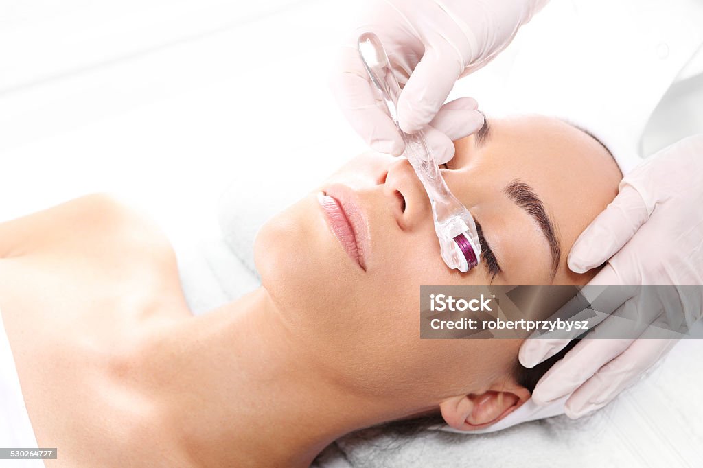 Mesotherapy microneedle, the woman at the beautician Beautician performs a needle mesotherapy treatment on a woman's face Collagen Induction Therapy Stock Photo