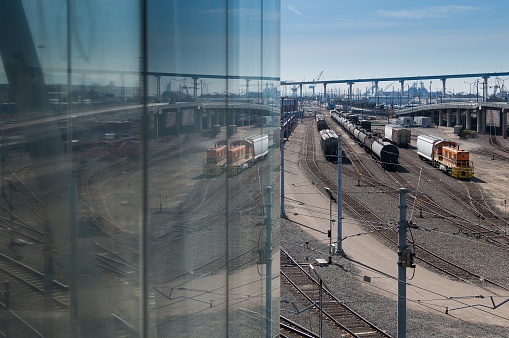 An interesting reflective view of railway tracks and trains near the docks in San Diego, CA.