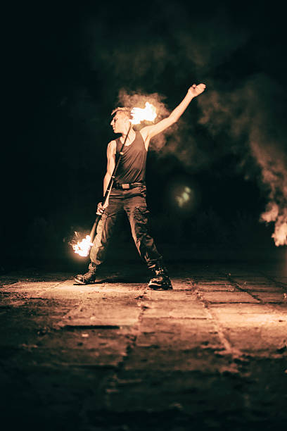 istock active European guy carries out tricks for fire show night 530275963