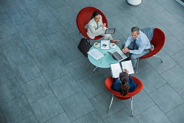 High angle view of businesspeople discussing strategy at coffee table in office
